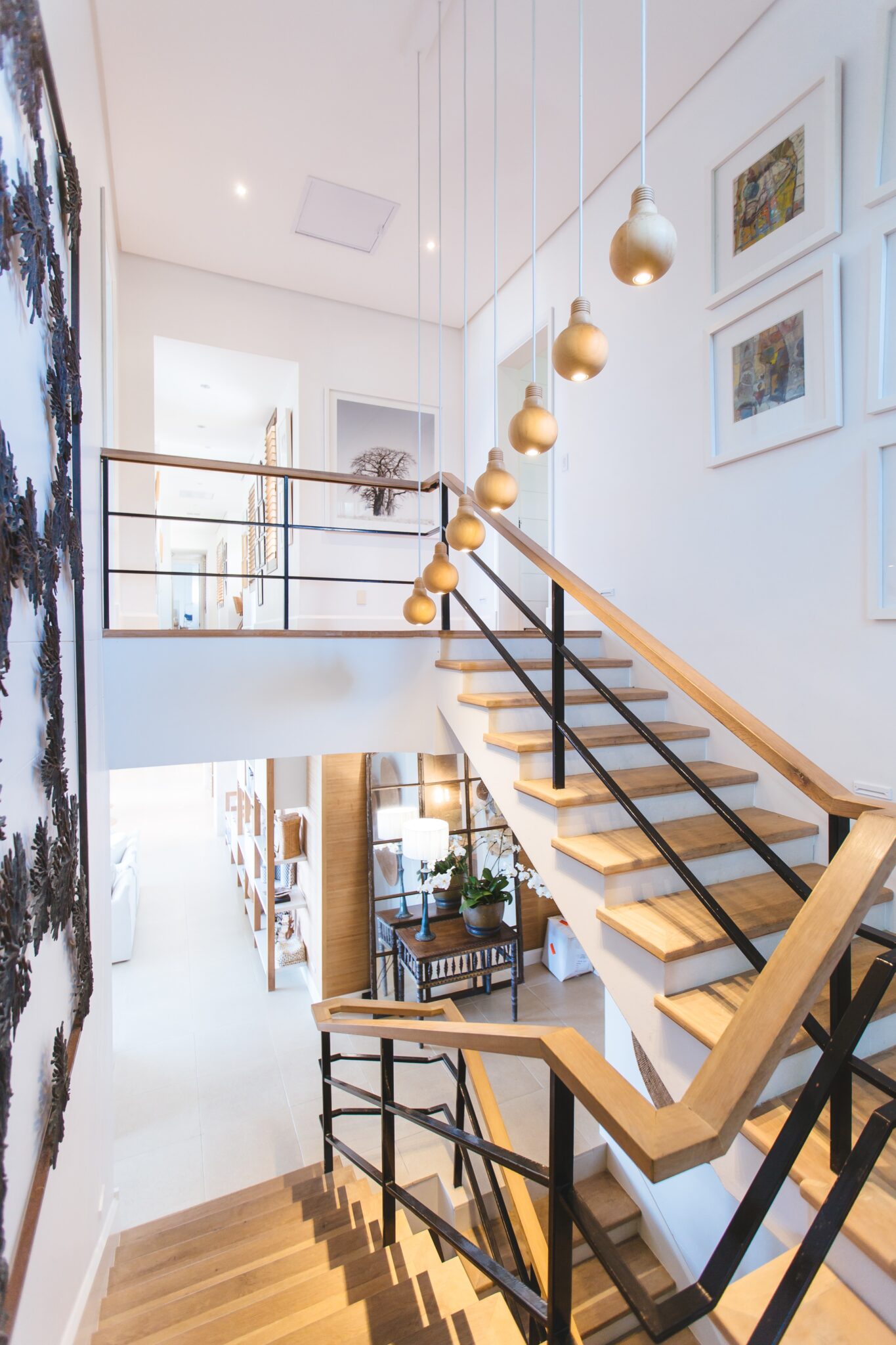 A staircase with lights and pictures on the wall.